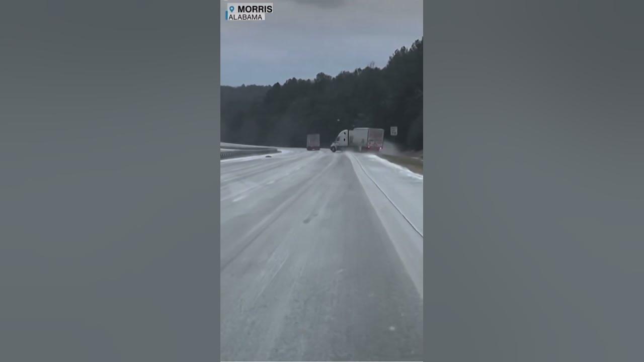 Video captures a semi-trailer truck losing control on an icy highway crashing into guardrails.